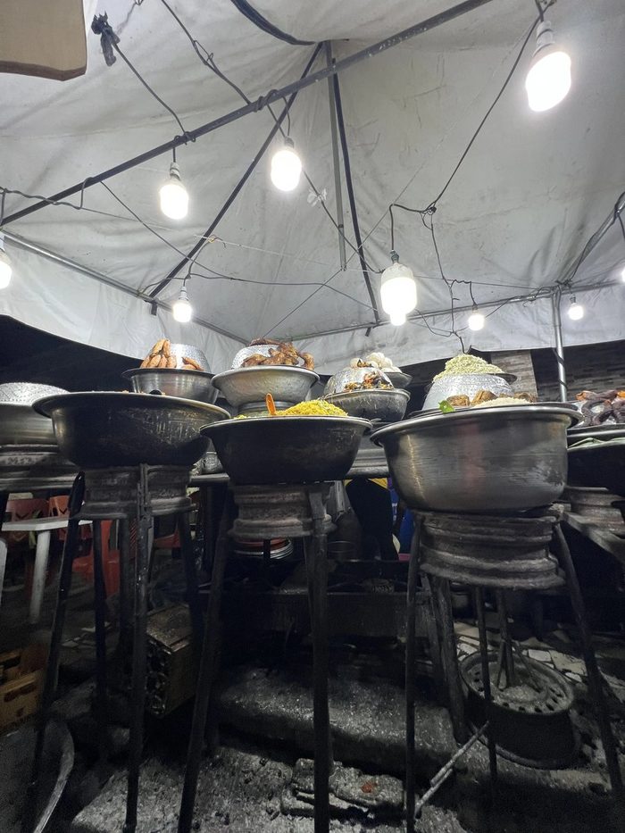 Pots of food at a night street food stall